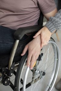 young adult helping disabled friend scaled